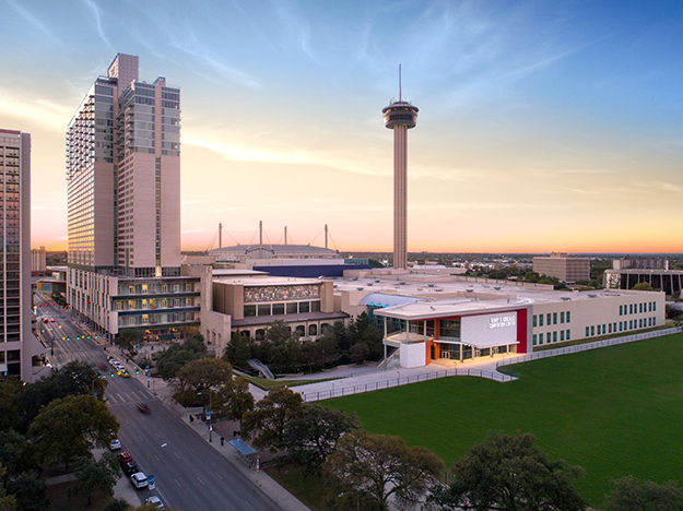 The Grand Hyatt towers over the nearby Henry B. González Convention Center. The Tower of the Americas observation tower appears in the distance.